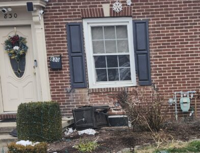 PHILIP A. HOLMES/Sun-Gazette After the pickup truck was pulled away from the house on Faxon Parkway, damage to the exterior of the home was clearly evident. The truck struck the house's water line and narrowly hit the gas line to the property.
